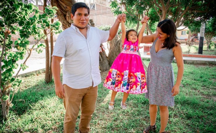 man in white polo shirt standing beside girl in pink floral dress